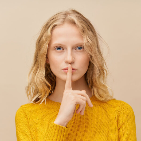 waist up portrait of woman putting finger to lips q4grutl 1.jpg